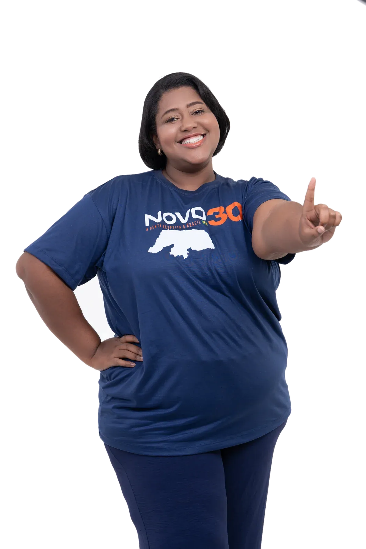 Camila Georg sorrindo, com a camiseta do NOVO 30 e o mapa do Rio Grande do Norte, apontando para frente